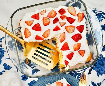 Strawberry Twinkie Dessert sits in a cake pan with a slice lifter.