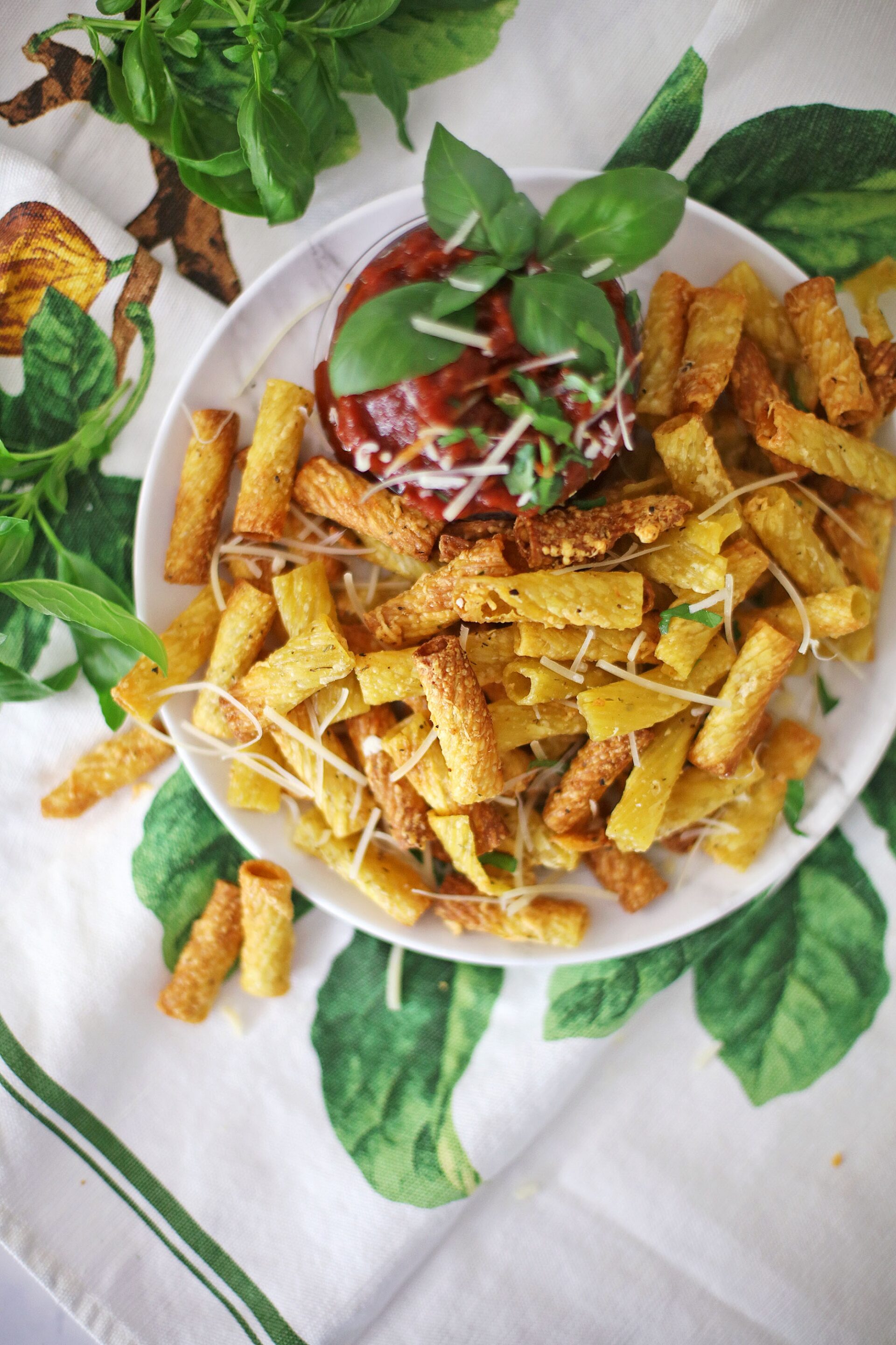 Air fryer pasta chips on a plate with dipping sauce.