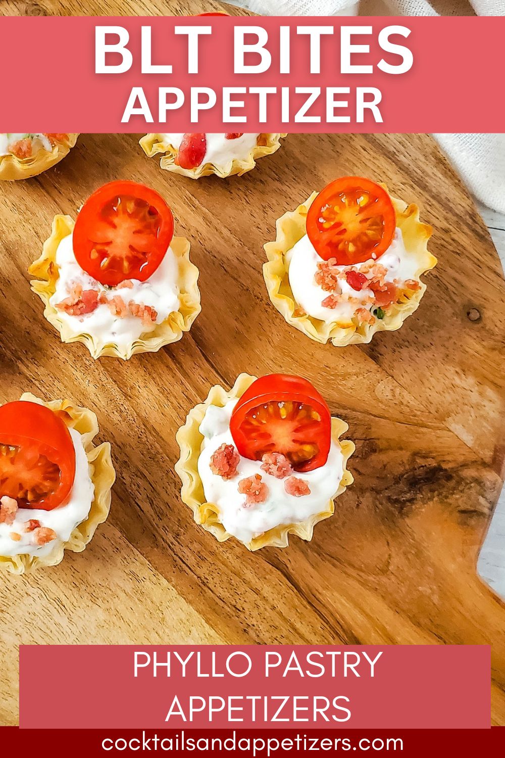 BLT Bites with cherry tomato garnish in phyllo shell on wood table.