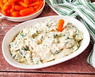 Knorr Spinach Dip Recipe in a serving bowl with carrot sticks for dipping.