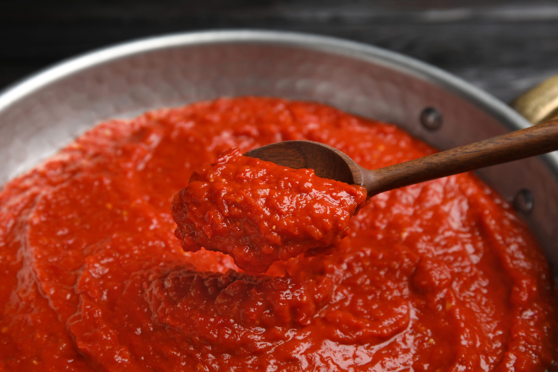 Stirring tomato sauce with a spoon.