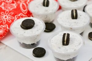 Chocolate Vodka pudding shots in shot cups with Oreo cookie garnish.