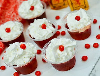 Fireball Jello Shots with Red Hots candy garnish and whipped cream.