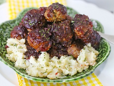 Stove Top Stuffing meatballs with BBQ sauce sit on a bed of mashed potatoes.