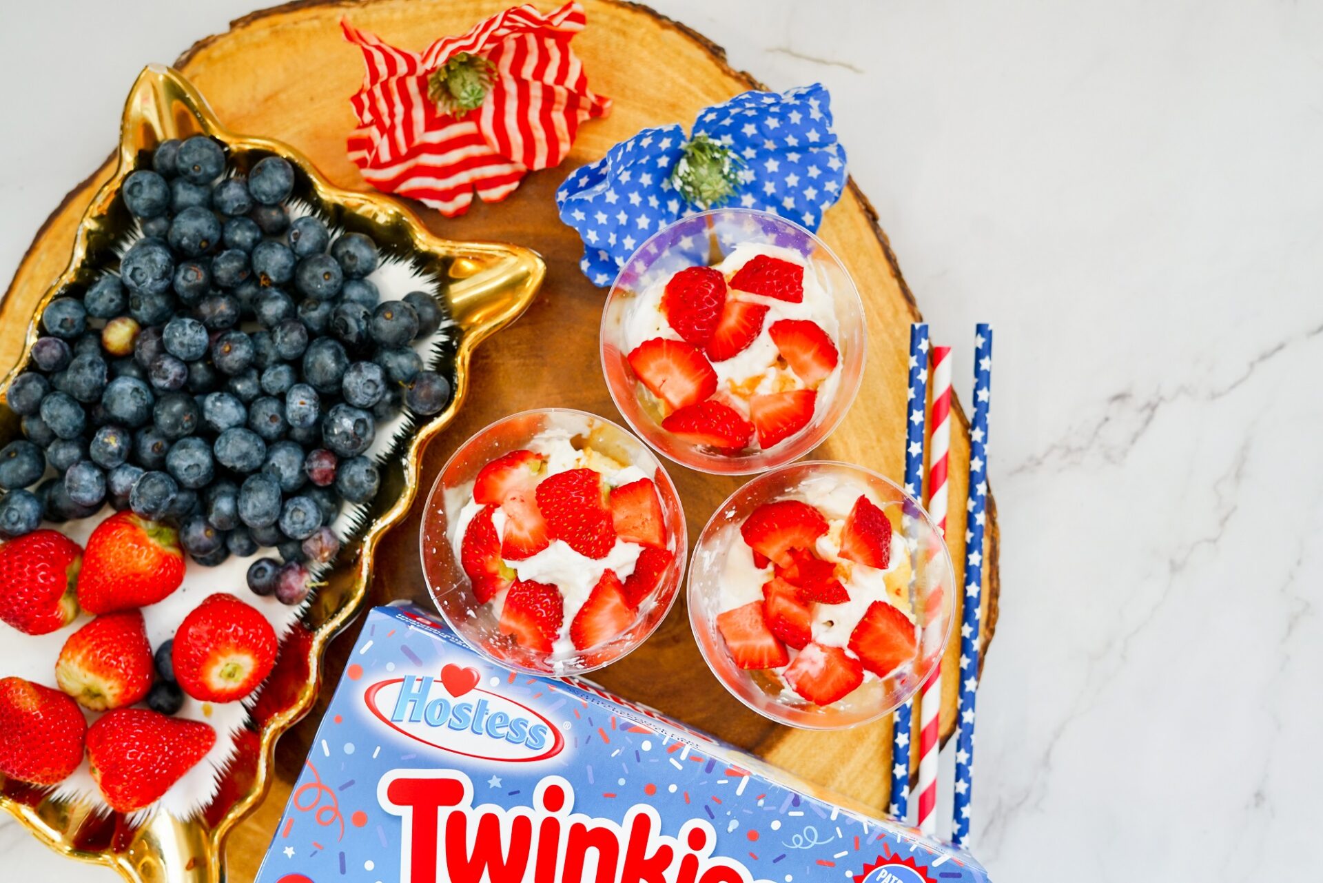 Adding strawberry slices to twinkie cups.