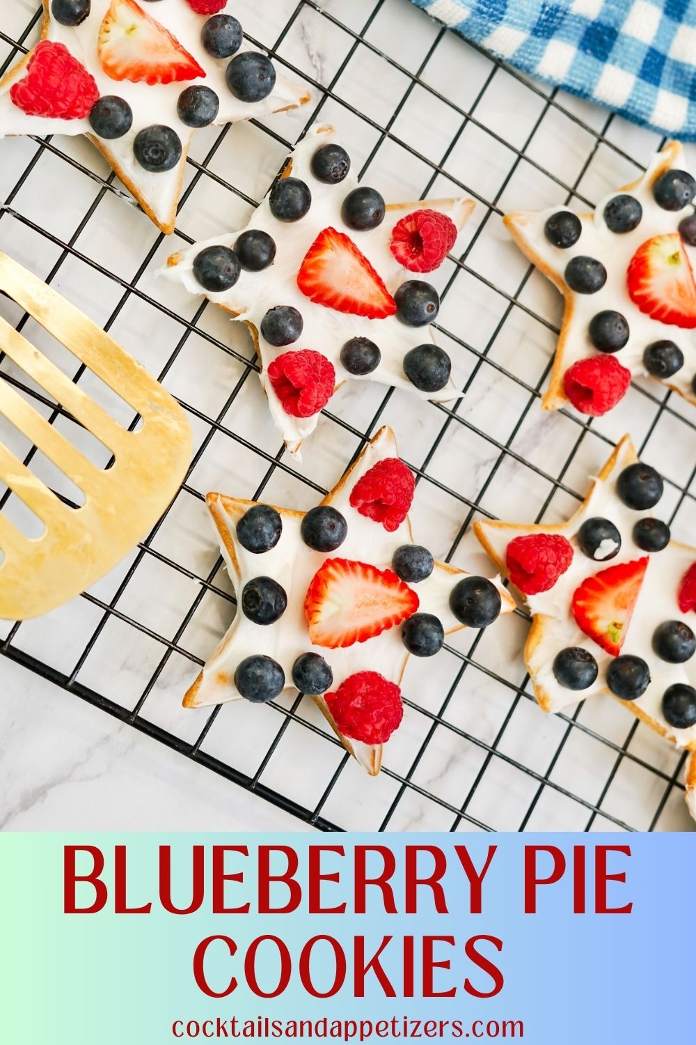 Blueberry Pie cookies frosted with berries on top sit on a cooling rack. 