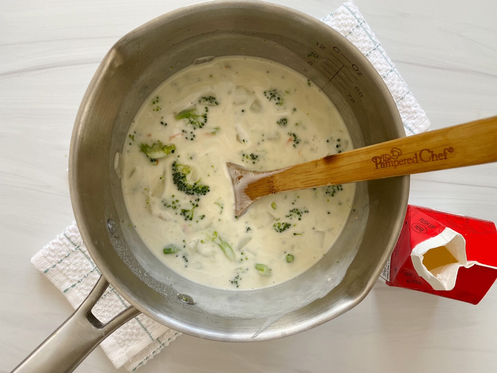 Mixing cream into broccoli cheese soup.