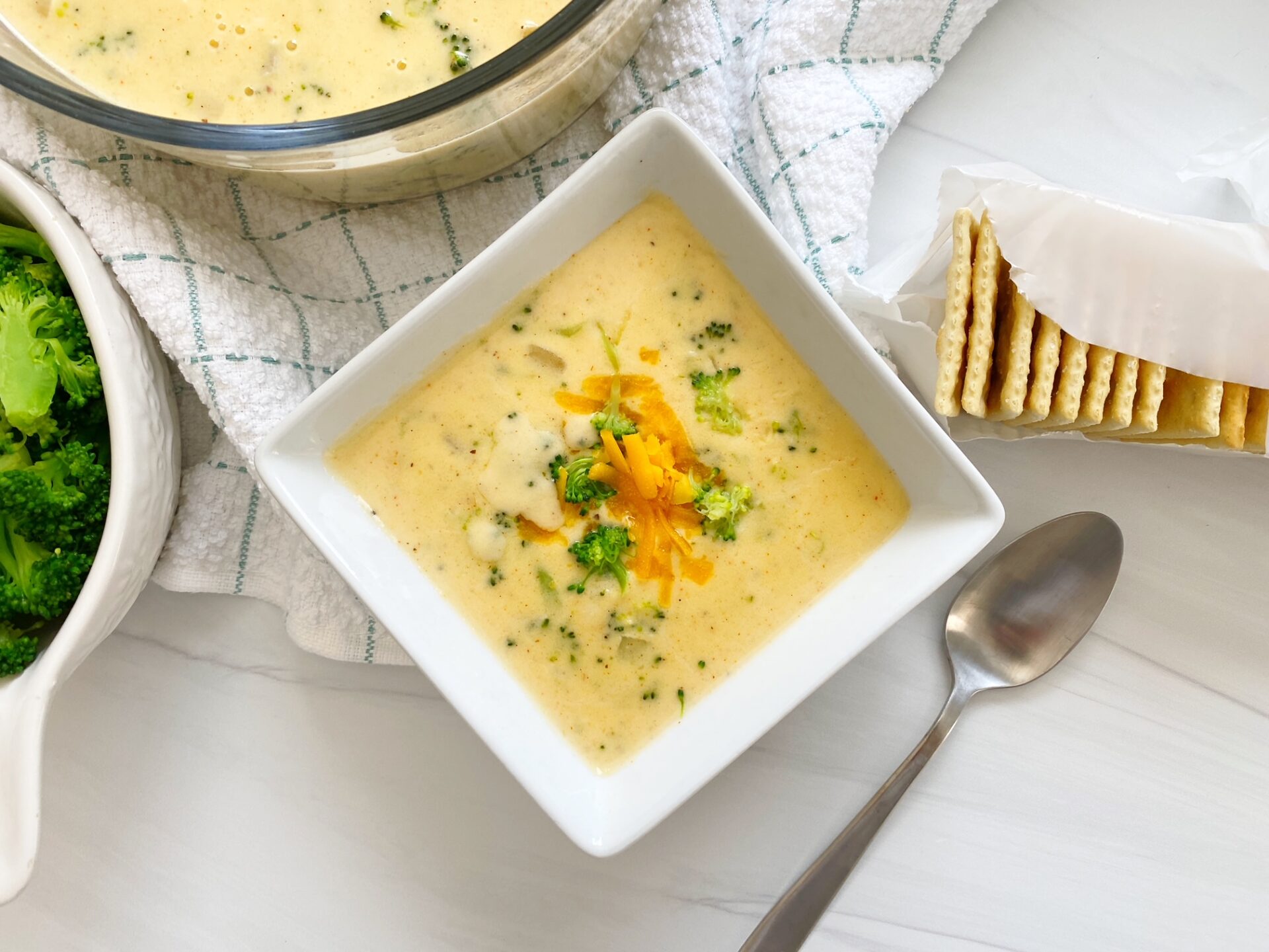 Broccoli cheese soup in a square bowl.