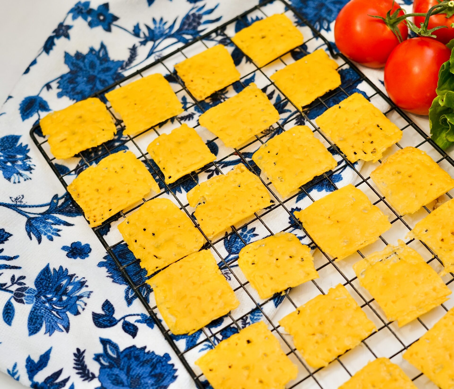 Cheddar cheese crisps cooling on a cooling rack.