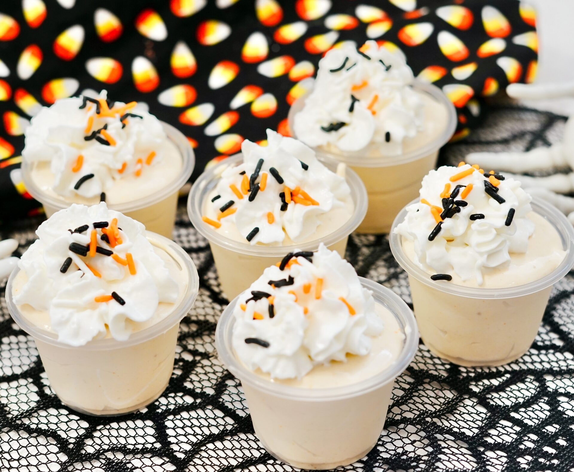 Rumchata pudding shots on a counter with Halloween decor.