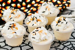 Rumchata pudding shots with whipped cream and sprinkles on a tray
