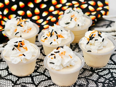 Rumchata pudding shots with whipped cream and sprinkles on a tray