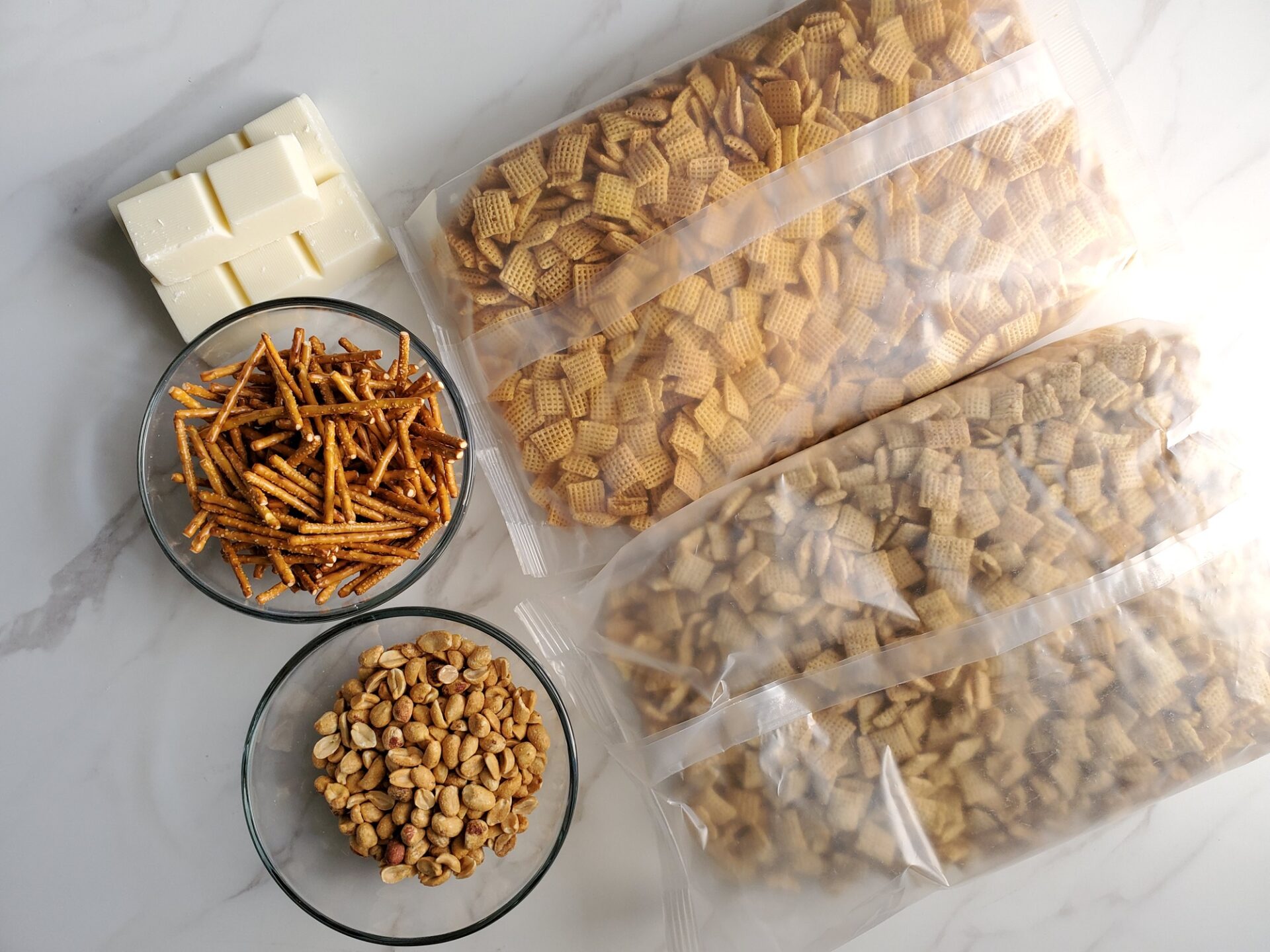 Ingredients for white chocolate chex mix on a counter.