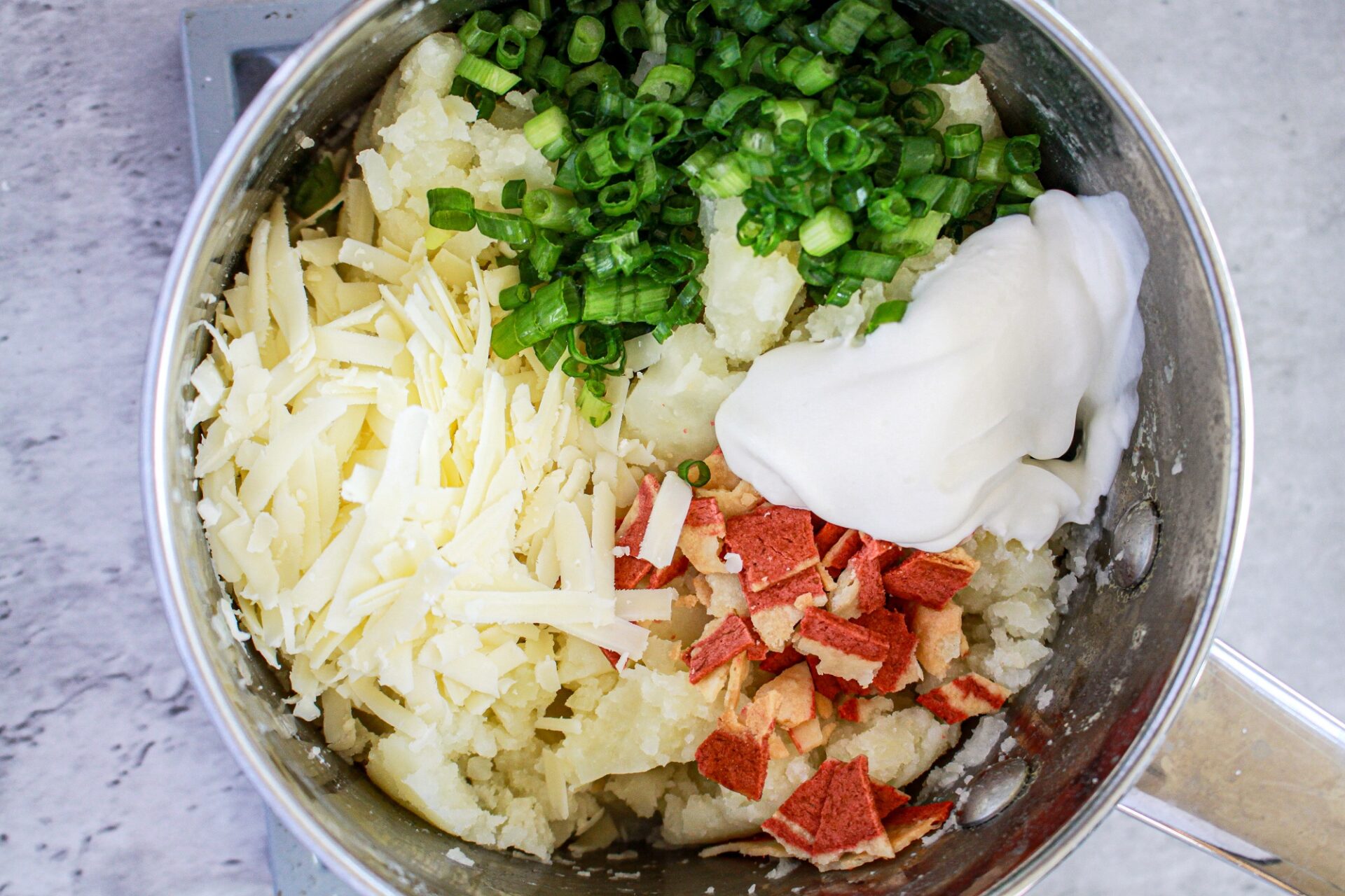 Combining ingredients for baked potato appetizers in a mixing bowl.