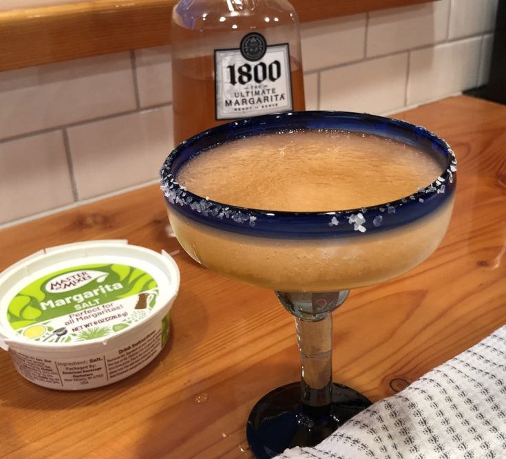 1800 Ultimate Margarita Mix Watermelon cocktails on a wood counter.