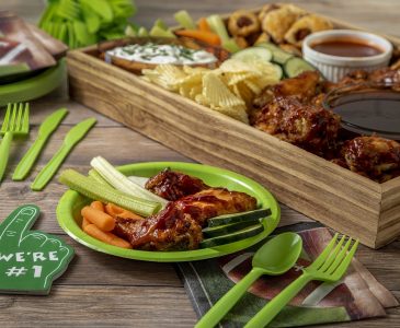 Last minute football food recipes on table including chicken wings, veggie dips and precut veggies.