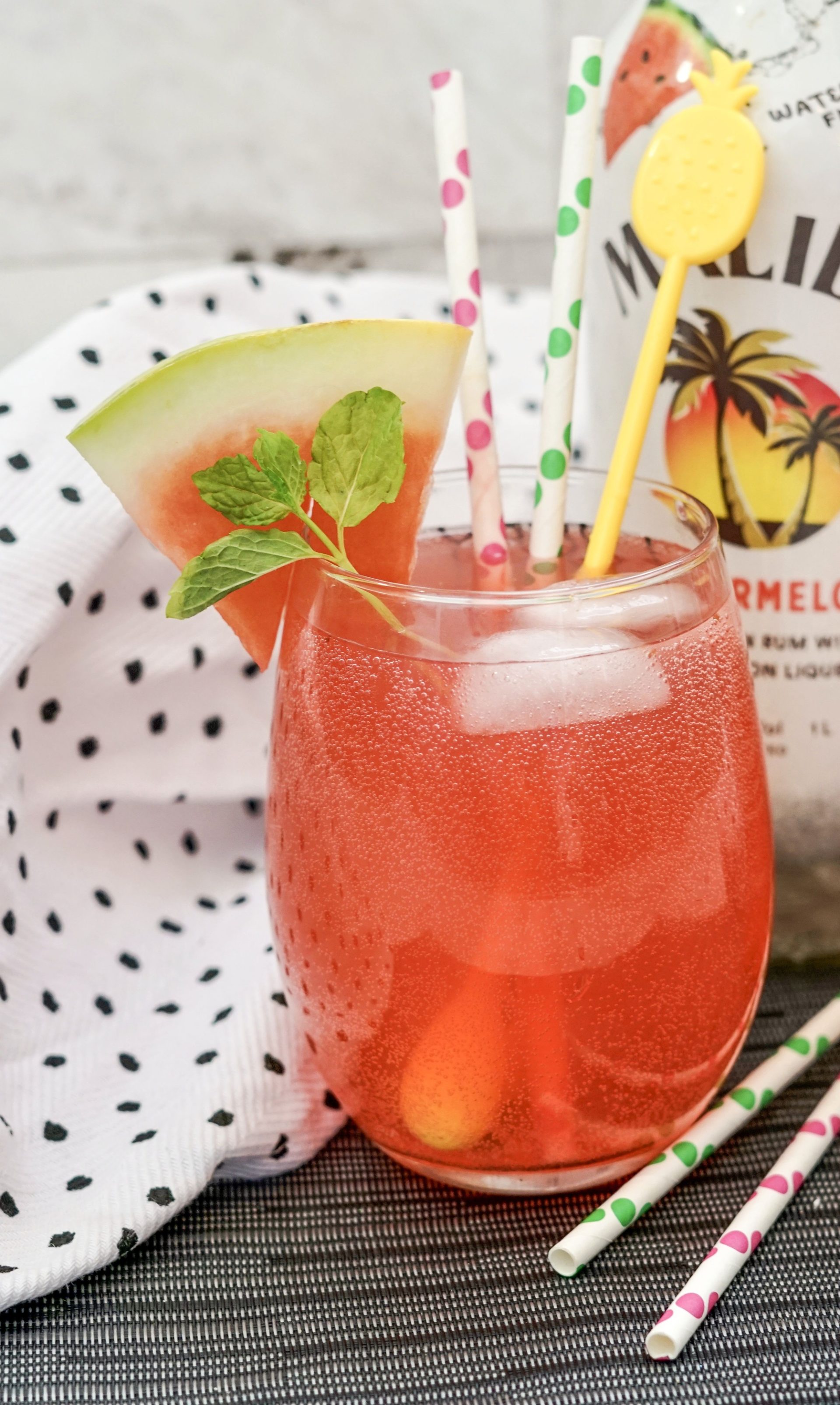 Malibu Watermelon Rum Fizz in a highball glass with ice. Garnished with mint and watermelon slice.