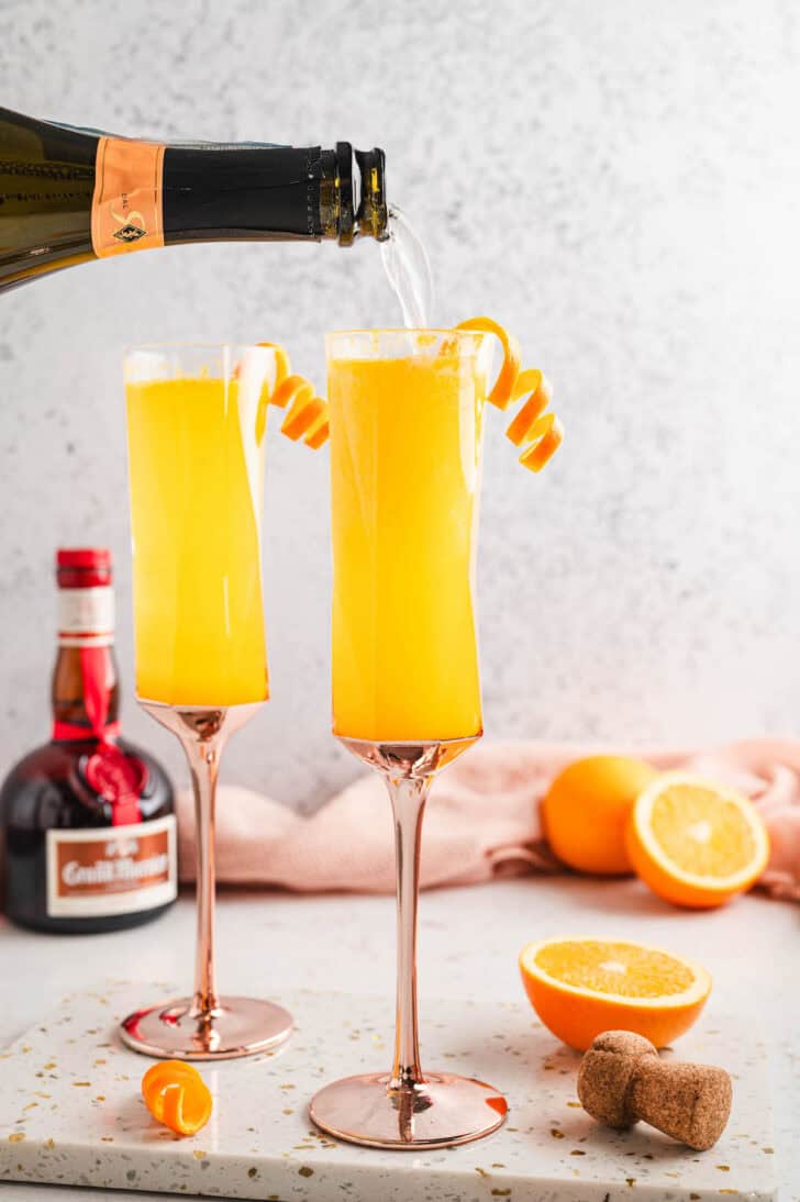 Big batch mimosas in flute glasses on a table.