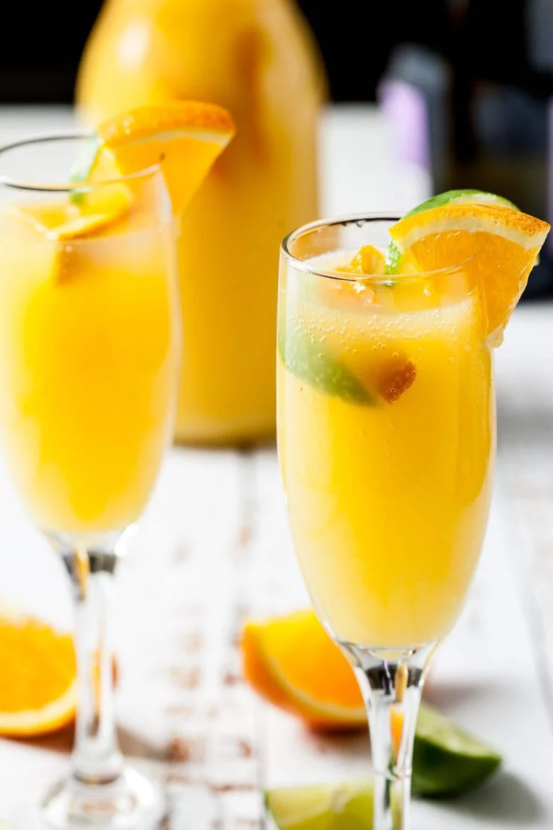 Classic mimosas in flute glasses sit on a table.