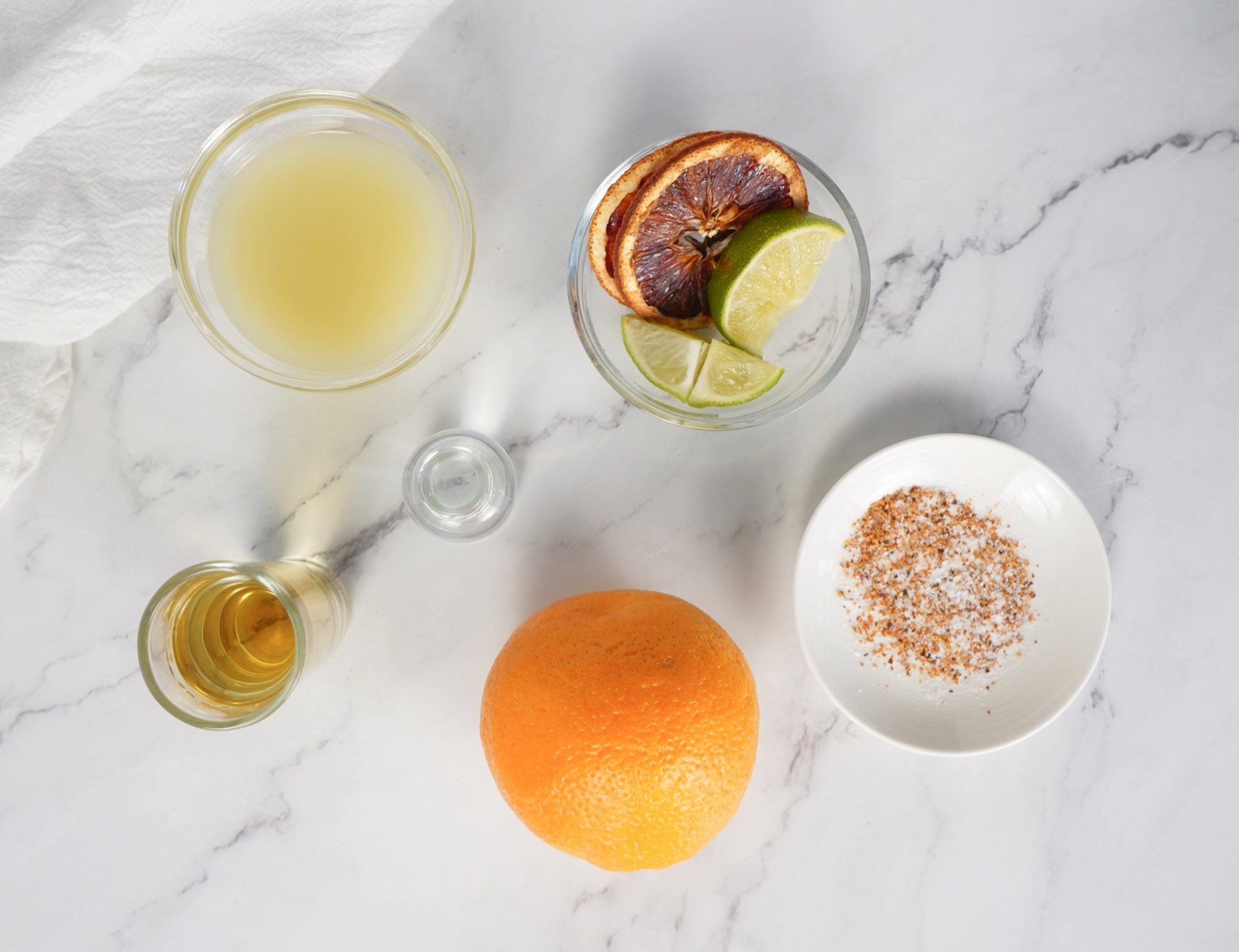 Blood orange margarita cocktail recipe ingredients on a counter.